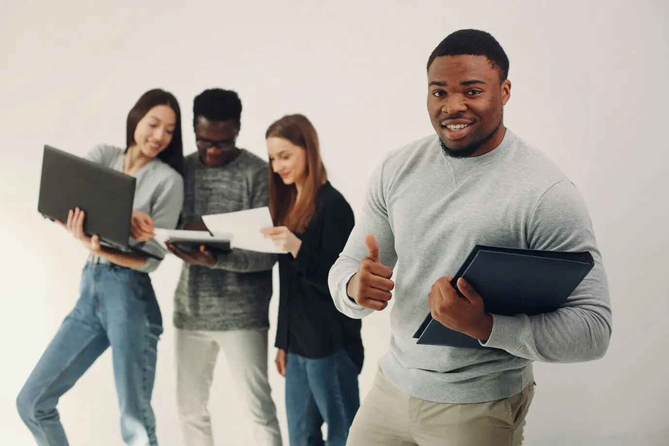 Junge internationale Personen arbeiten gemeinsam und verwenden den Laptop.